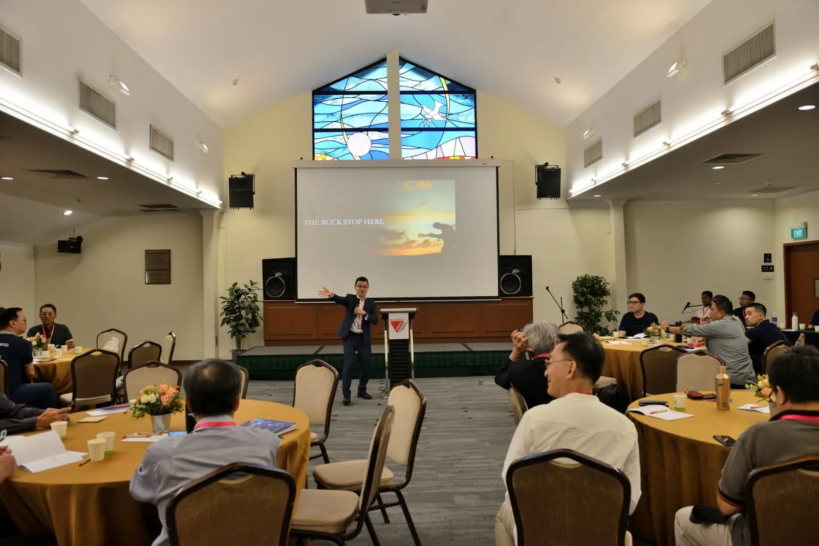 Members gathered at round tables during a fellowship session